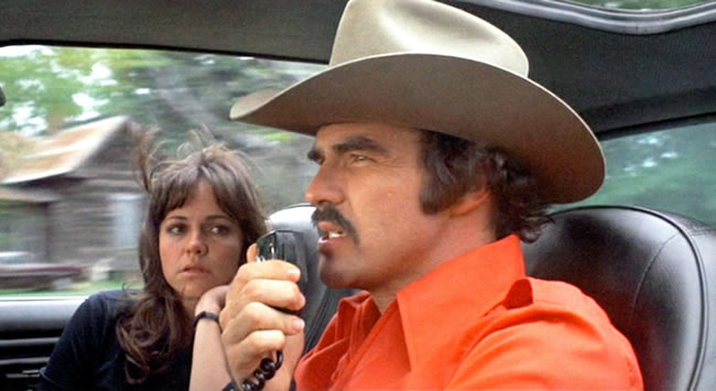 Burt Reynolds le pregunta a su compañero de ruta si conoce dónde encontrar un buen libretista en esta escena de Smokey and the Bandit (1977) 